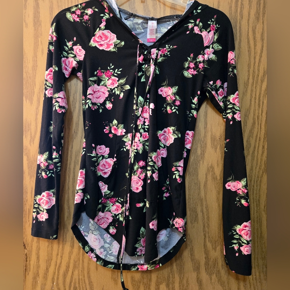 Pretty, long sleeve black blouse with pink flowers, lace-up neck and hood.